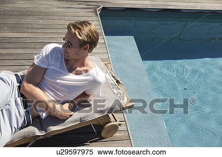 Man relaxing by swimming pool View Large Photo Image Stock Photography - Man relaxing by swimming pool. Fotosearch