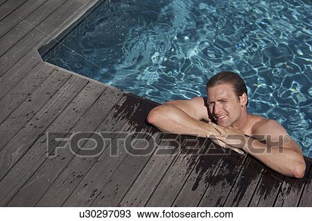 Stock Image - Man relaxing in swimming pool. Fotosearch