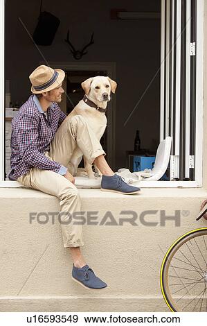 Man sitting with dog in windowsill View Large Photo Image Stock Photo - Man sitting with dog in windowsill. Fotosearch