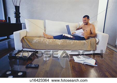 Man studying with laptop in living room View Large Photo Image Picture - Man studying with laptop in living room. Fotosearch
