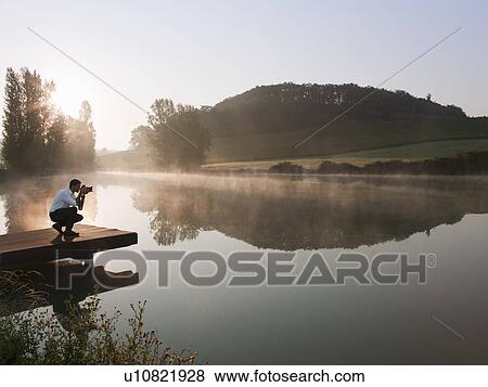 Man taking pictures of lake View Large Photo Image Stock Photo - Man taking pictures of lake. Fotosearch