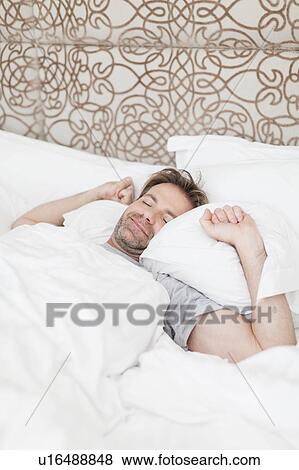 Man waking up in bed View Large Photo Image Stock Photo - Man waking up in bed. Fotosearch