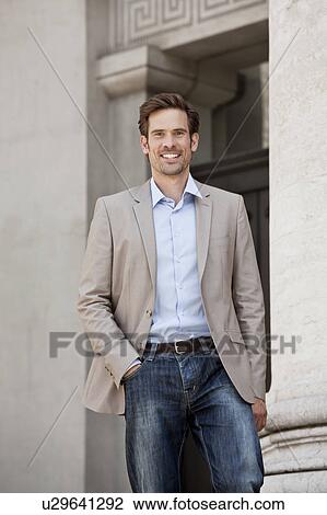Stock Image - Man walking by columned building. Fotosearch