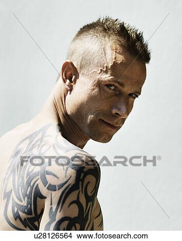 Man with tribal tattoo on shoulder View Large Photo Image Picture - Man with tribal tattoo on shoulder. Fotosearch