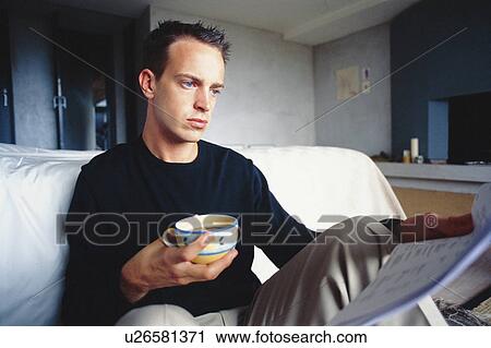 Stock Image - Man working with coffee in bedroom . Fotosearch