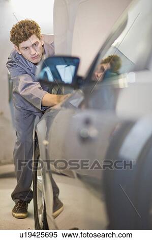 Mechanic examining car in garage View Large Photo Image Stock Photography - Mechanic examining car in garage. Fotosearch