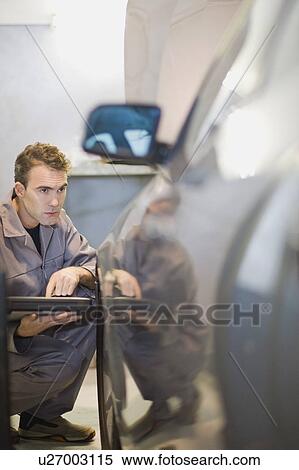 Stock Photography - Mechanic examining car in garage. Fotosearch