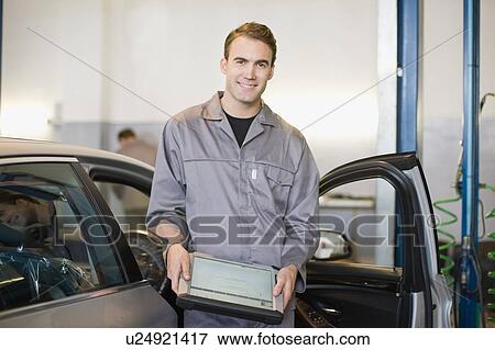Stock Photo - Mechanic with tablet computer in garage. Fotosearch