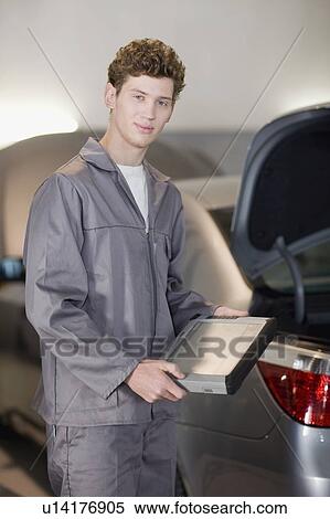 Stock Photography - Mechanic with tablet computer in garage. Fotosearch