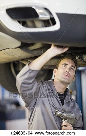 Picture - Mechanic working on car in garage. Fotosearch