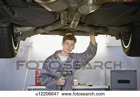Mechanic working on car in garage View Large Photo Image Stock Photo - Mechanic working on car in garage. Fotosearch