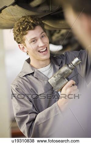 Mechanic working on car in garage View Large Photo Image Stock Photo - Mechanic working on car in garage. Fotosearch