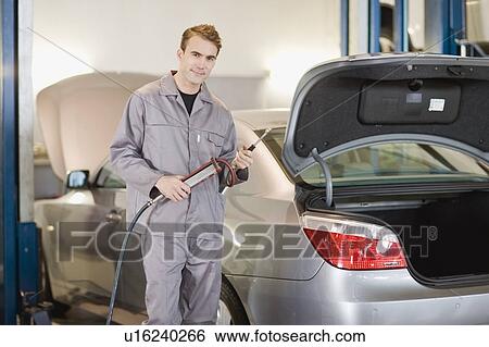 Mechanic working on car in garage View Large Photo Image Stock Photograph - Mechanic working on car in garage. Fotosearch