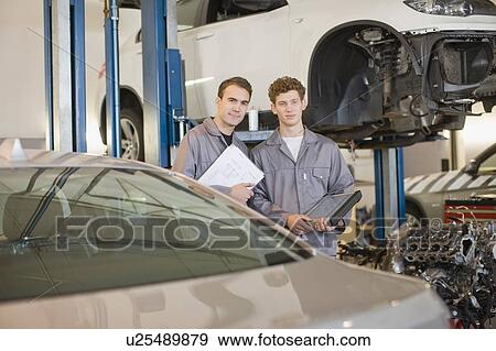 Stock Photo - Mechanics working in garage. Fotosearch
