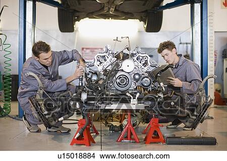 Picture - Mechanics working on car engine. Fotosearch