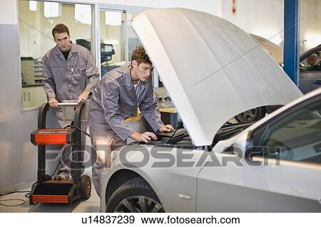 Mechanics working on car engine View Large Photo Image Stock Photo - Mechanics working on car engine. Fotosearch