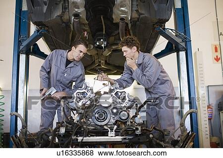 Stock Photo - Mechanics working on car engine. Fotosearch
