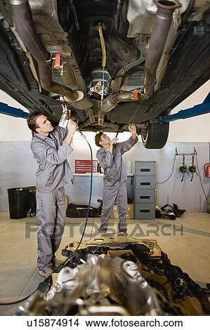 Picture - Mechanics working on car in garage. Fotosearch