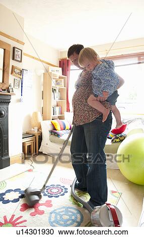 Mother holding toddler while vacuuming View Large Photo Image Stock Image - Mother holding toddler while vacuuming. Fotosearch