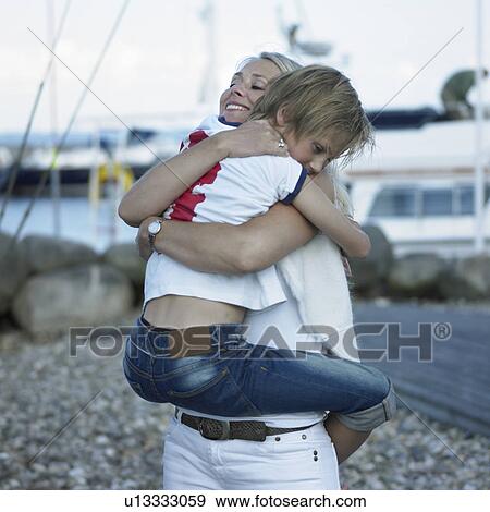 Stock Photo - Mother hugging son outdoors. Fotosearch