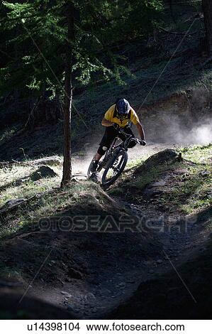 Mountain biker on dirt path View Large Photo Image Picture - Mountain biker on dirt path. Fotosearch