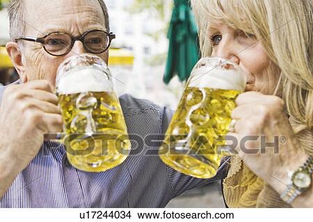 Picture - Older couple drinking beer together. Fotosearch