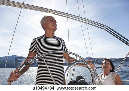 Picture - Older couple relaxing on sailboat. Fotosearch