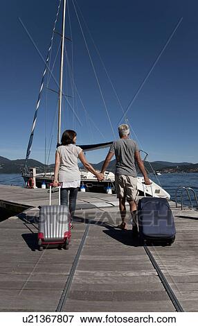 Older couple rolling luggage on pier View Large Photo Image Stock Photo - Older couple rolling luggage on pier. Fotosearch