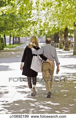 Older couple walking in park together View Large Photo Image Stock Photo - Older couple walking in park together. Fotosearch