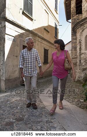 Older couple walking on cobbled street View Large Photo Image Stock Photography - Older couple walking on cobbled street. Fotosearch