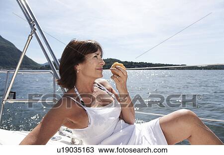 Older woman eating on sailboat View Large Photo Image Stock Image - Older woman eating on sailboat. Fotosearch