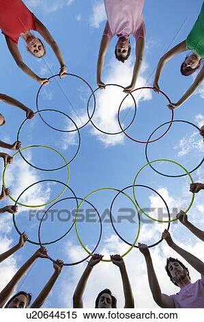 Stock Photography - People holding hula hoops in circle. Fotosearch