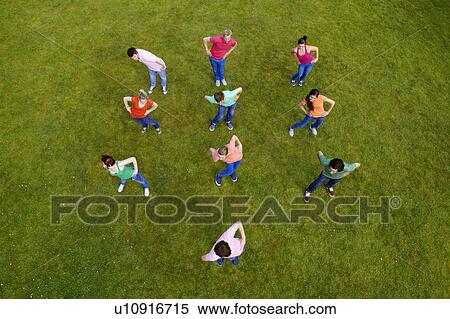 Stock Photography - People stretching together in grass. Fotosearch