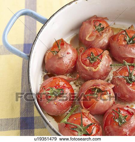 Stock Photo - Pot of bacon wrapped tomatoes. Fotosearch