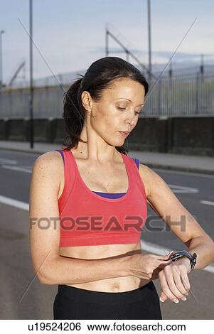 Runner checking her watch View Large Photo Image Stock Photograph - Runner checking her watch. Fotosearch