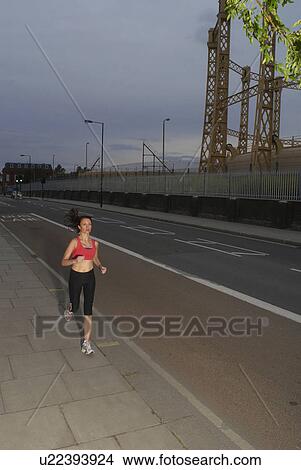 Runner jogging on city street View Large Photo Image Picture - Runner jogging on city street. Fotosearch