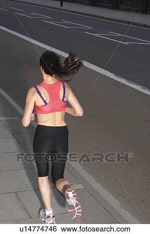 Runner jogging on city street View Large Photo Image Stock Photograph - Runner jogging on city street. Fotosearch