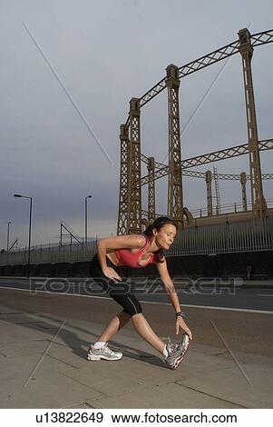 Runner stretching on city street View Large Photo Image Stock Photo - Runner stretching on city street. Fotosearch