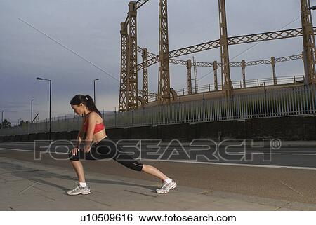 Runner stretching on city street View Large Photo Image Stock Photograph - Runner stretching on city street. Fotosearch