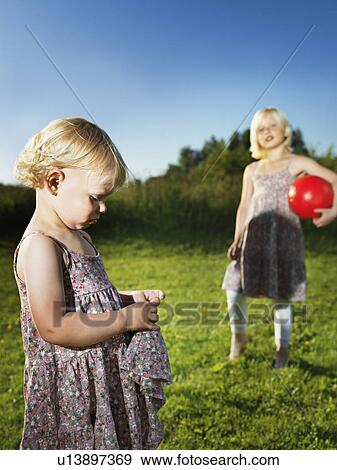 Sad toddler girl playing with sister View Large Photo Image Stock Photo - Sad toddler girl playing with sister. Fotosearch