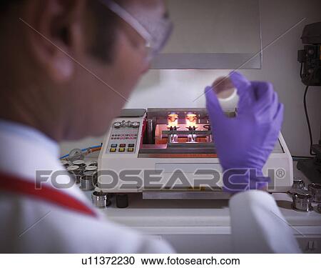 Stock Image - Scientist examining sample in lab. Fotosearch