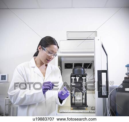 Scientist putting liquid in beaker View Large Photo Image Stock Photo - Scientist putting liquid in beaker. Fotosearch