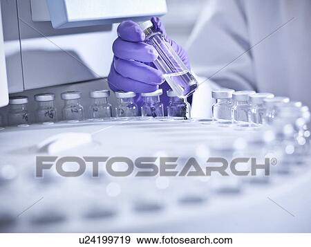 Stock Photo - Scientist using equipment in lab. Fotosearch