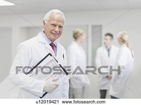 Stock Image - Scientist with notes in pathology lab. Fotosearch