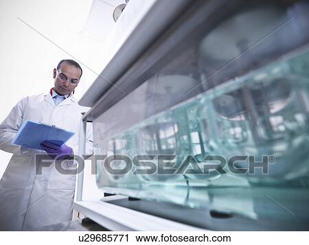 Scientist working on equipment in lab View Large Photo Image Stock Image - Scientist working on equipment in lab. Fotosearch