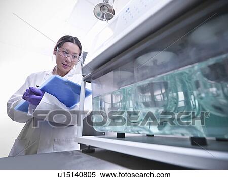Stock Photography - Scientist working on equipment in lab. Fotosearch