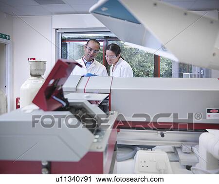 Scientists working on equipment in lab View Large Photo Image Stock Image - Scientists working on equipment in lab. Fotosearch