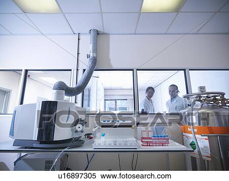 Stock Photography - Scientists working on equipment in lab. Fotosearch