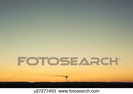 Stock Image - Silo against sunset sky. Fotosearch