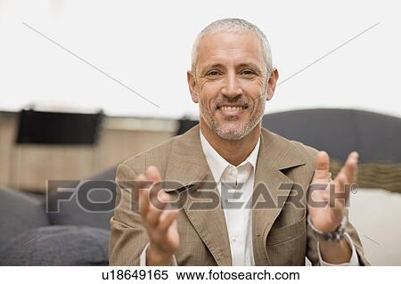 Smiling businessman talking on couch View Large Photo Image Stock Photography - Smiling businessman talking on couch. Fotosearch